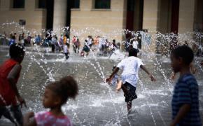 Children enjoy the fountains on a hot Summer day.